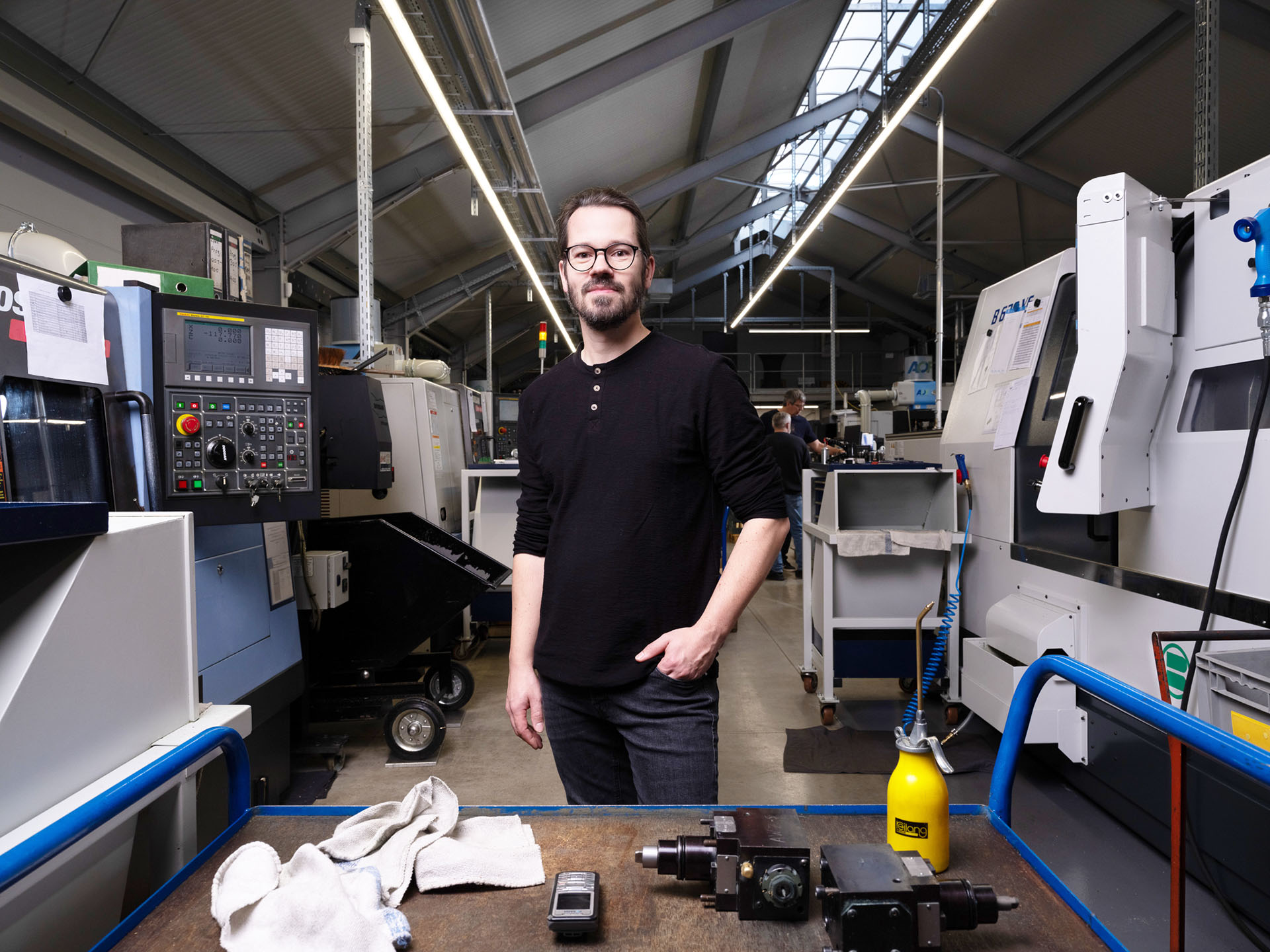 Mitarbeiter in der Fertigung von Peter Kröner GmbH: Ein Arbeitsplatz mit CNC-Maschinen und Werkzeugen, die für die präzise Herstellung von Produkten für die Partikelschaumindustrie (z. B. Injektoren, Entlüftungsdüsen) genutzt werden.