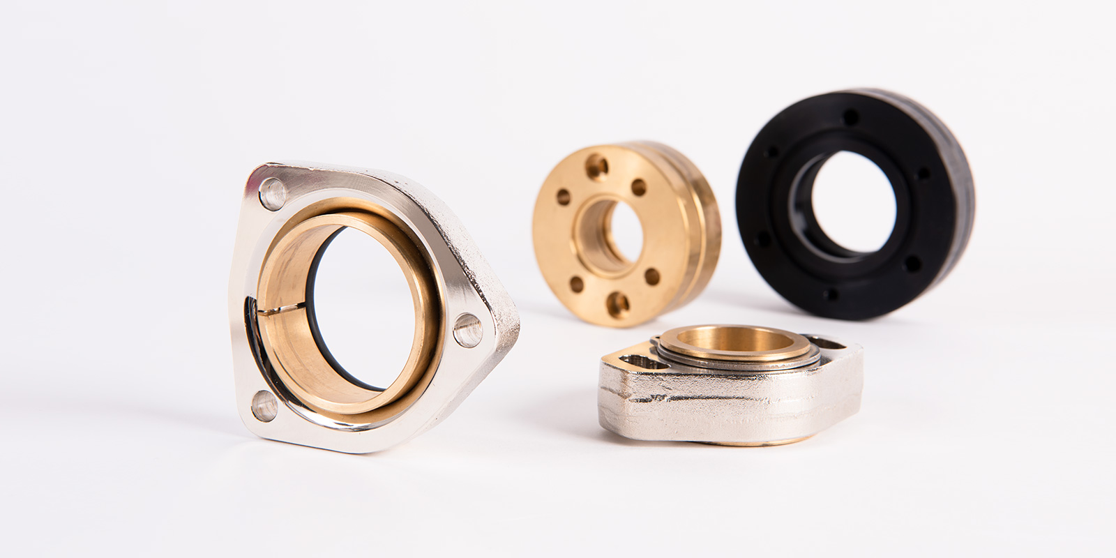 Metallische und messingfarbene Halterungen sowie Dichtelemente für die Partikelschaumindustrie – Produkte von Die Peter Kröner GmbH, spezialisiert auf Injektoren und Zubehör für industrielle Anwendungen.