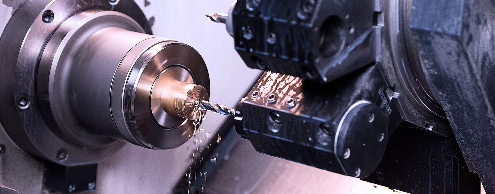 CNC-gesteuerte Präzisionsbearbeitung eines metallischen Werkstücks mit Bohrwerkzeug – Beispiel für die hochgenaue Fertigungstechnologie von Peter Kröner GmbH, die für die Partikelschaumindustrie und industrielle Anwendungen entwickelt wird.