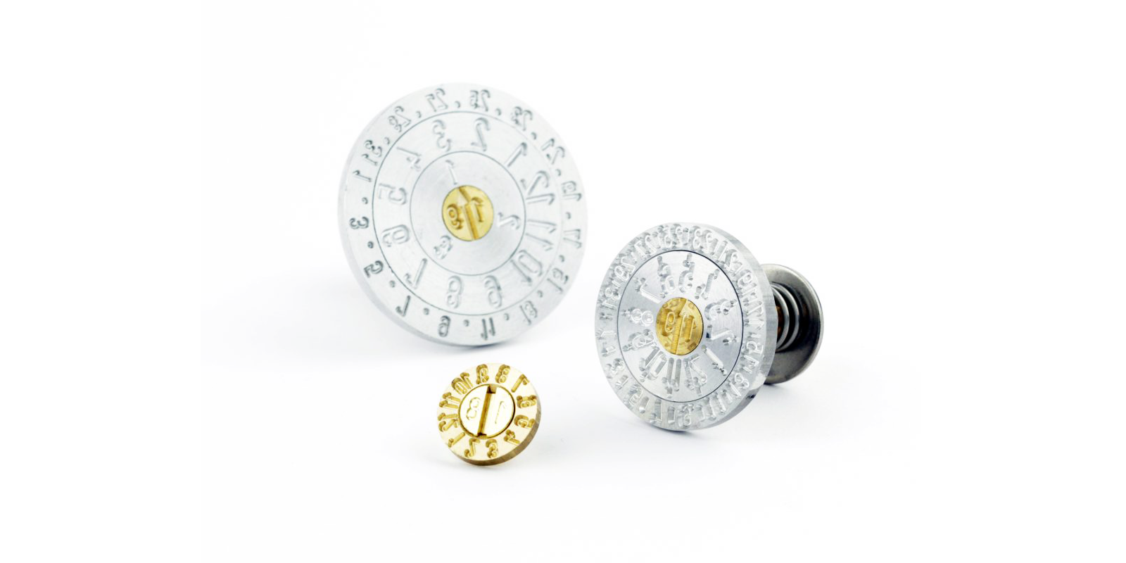 Drei metallene Stempel- oder Dosierteile mit numerischen Markierungen und goldenen Zentren, entwickelt von Peter Kröner GmbH für die industrielle Verarbeitung von Partikelschäumen wie EPS, EPP und ETPU.